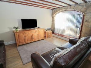 a living room with a couch and a flat screen tv at The Mistal in Glanton