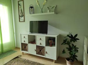 ein Wohnzimmer mit einem TV auf einem weißen Schrank in der Unterkunft Oasis o,xuncal in San Cosme de Barreiros