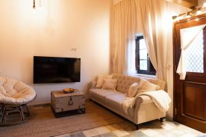 a living room with a couch and a flat screen tv at Chalet du Solei- V022 in Salema