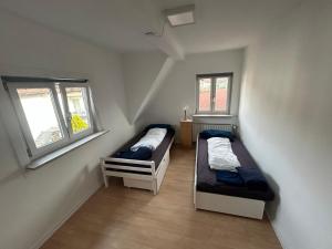 two beds in a room with two windows at Zauberblick in Lindenfels