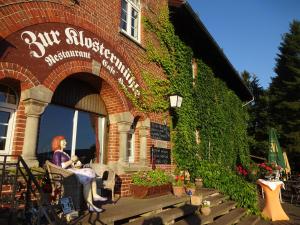 a woman sitting in a chair outside of a building at Klostermühle Bursfelde in Hannoversch Münden