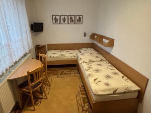 a small room with two beds and a table at Apartment Skurčák in Zuberec