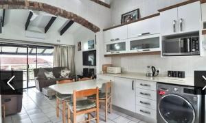 a kitchen and living room with a table and chairs at Natspat 10 in Margate