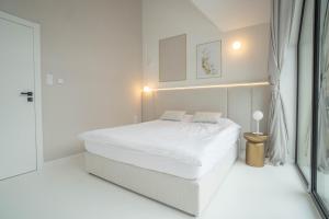 a white bedroom with a bed and a window at House Prestige Glam in Gliczarów Górny