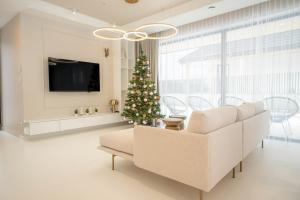 a living room with a christmas tree and a white couch at House Prestige Glam in Gliczarów Górny +12 photos