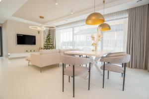 a dining room with a table and chairs and a christmas tree at House Prestige Glam in Gliczarów Górny