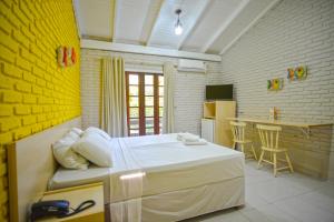 ein Schlafzimmer mit großem Bett und eine Küche in der Unterkunft Morro do Sol Hotel & Eventos in Porto Belo + 37 Fotos