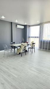 Cette chambre comprend une table et des chaises avec un animal farci. dans l'établissement Penthouse in Almaty!, à Almaty