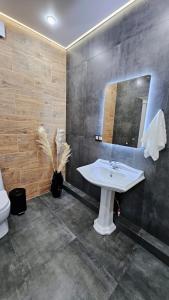 une salle de bain avec un lavabo et un miroir dans l'établissement Penthouse in Almaty!, à Almaty 35 autres photos