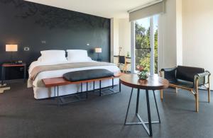 a bedroom with a bed and a table and chairs at Hotel Ismael - Lastarria in Santiago