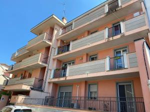 un edificio de apartamentos con balcones y un coche aparcado enfrente en La dimora del viaggiatore, en Vigevano