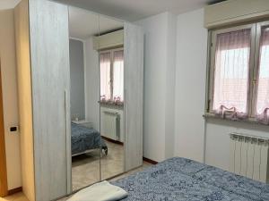 1 dormitorio con espejo y 2 camas. en La dimora del viaggiatore, en Vigevano