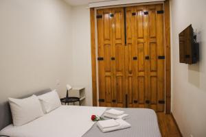 a bedroom with a bed and a wooden door at PBH Hostel in Porto