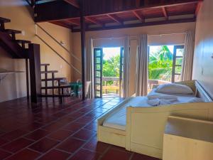 ein Schlafzimmer mit einem Bett und einem großen Fenster in der Unterkunft Morro do Sol Hotel & Eventos in Porto Belo