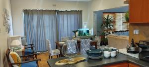 cocina y sala de estar con mesa y copa de vino en karoo welcome, en Beaufort West