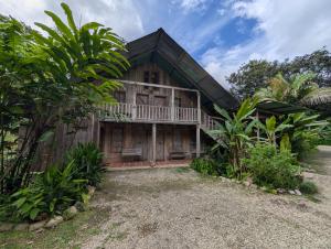 a wooden house with a balcony and trees at Hotel La Gamba Rainforest Lodge in Golfito