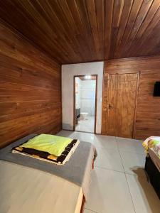 Pântano GrandeにあるQuarto em casa familiarの木製の壁の部屋にあるベッドのある寝室