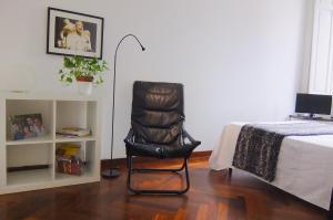 ローマにあるBianco E Nero Apartmentのベッドの横の部屋に座る黒い椅子