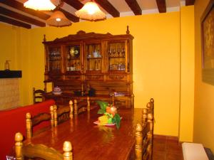 a dining room with a table and a wooden cabinet at Casa Rural San Anton Cuenca in El Provencio