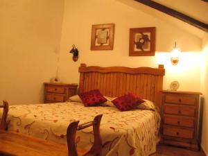 Un dormitorio con una cama con almohadas rojas. en Casa Rural San Anton Cuenca, en El Provencio