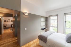 een slaapkamer met een groot bed en een eetkamer bij CdC Apartments by Casa do Conto in Porto