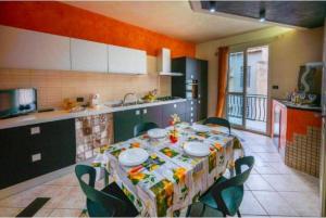 a kitchen with a table with chairs and a table cloth at 1st floor apartment in the city - air conditioned - wifi in Avola +13 photos