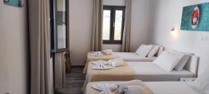 a room with two beds with towels on them at Ragousis Apartments in Parikia +111 photos