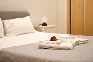 a bed with towels and a stuffed animal on it at PBH Hostel in Porto