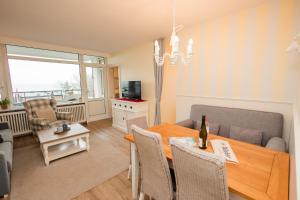 a living room with a dining room table and a couch at Haus Oland Wohnung 21 in Wyk auf Föhr