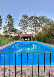 une grande piscine bleue avec un gazebo dans l'établissement Estancia Pozo de Correa, à Agua de las Piedras