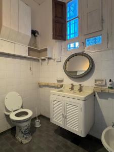 une salle de bain avec toilettes, lavabo et miroir dans l'établissement Estancia Pozo de Correa, à Agua de las Piedras
