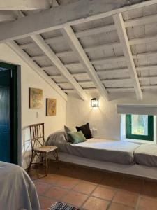 une chambre avec un lit, une chaise et une fenêtre dans l'établissement Estancia Pozo de Correa, à Agua de las Piedras