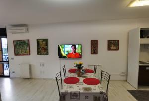 a dining room with a table and a tv on a wall at Ballarin Studio Apartment for Business Travels and Holidays in Rome
