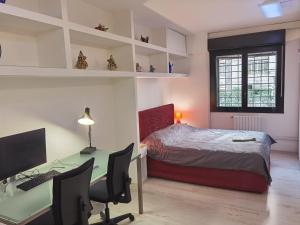 a bedroom with a bed and a desk with a computer at Ballarin Studio Apartment for Business Travels and Holidays in Rome