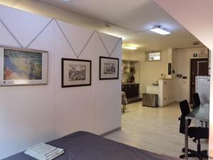 a room with a white wall with pictures on it at Ballarin Studio Apartment for Business Travels and Holidays in Rome