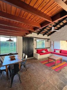 un salon avec une table et un canapé rouge dans l'établissement Estancia Pozo de Correa, à Agua de las Piedras