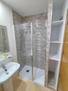 a bathroom with a shower and a sink at Luxury Ground Floor Apartment at Golf Resort Condado de Alhama with Private Garden & Pools in El Romero +20 photos