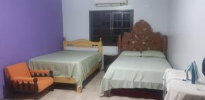 a bedroom with two beds and a chair and a window at Chacara barro branco in Foz do Iguaçu +24 photos
