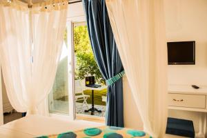 a bedroom with a bed and a window and a desk at Selin Hotel in Alaçatı