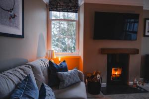 a living room with a couch and a fire place at Turret House in Crail