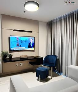 sala de estar con TV y silla azul en #2216# Flat lindo - Brookfield Towers, en Goiânia