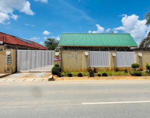 an empty street in front of a building with a green roof at Sandalwood Property in Lusaka