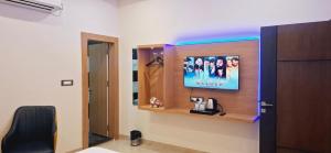 a room with a tv on a wall at BlueNeck Ayodhya-Near ShriRam Mandir in Ayodhya