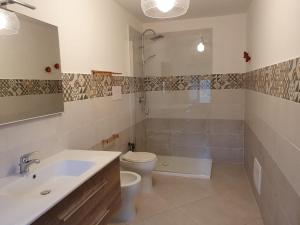a bathroom with a toilet and a sink and a shower at Affittacamere Nonna Ia in Lustra +24 photos