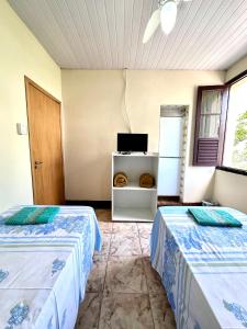 a room with two beds and a tv in it at Pousada Vó Celina in Belo Horizonte +25 photos
