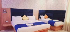 a bedroom with two beds with blue headboards at BlueNeck Ayodhya-Near ShriRam Mandir in Ayodhya