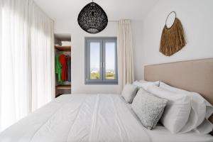 ein Schlafzimmer mit einem weißen Bett und einem Fenster in der Unterkunft Villa isola plaka Naxos in Plaka + 59 Fotos