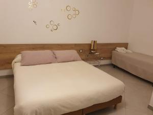 a bedroom with a white bed and a couch at Affittacamere Nonna Ia in Lustra