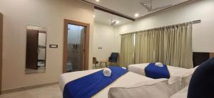 a hotel room with two beds and a bathroom at BlueNeck Ayodhya-Near ShriRam Mandir in Ayodhya