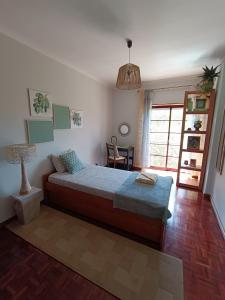 una camera da letto con un letto, un tavolo e una finestra di GREEN GARDEN APARTMENT IN ODIVELAS a Odivelas